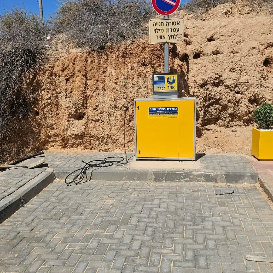 עמדת מילוי אוויר צהובה על רחבה מרוצפת באבנים משתלבות