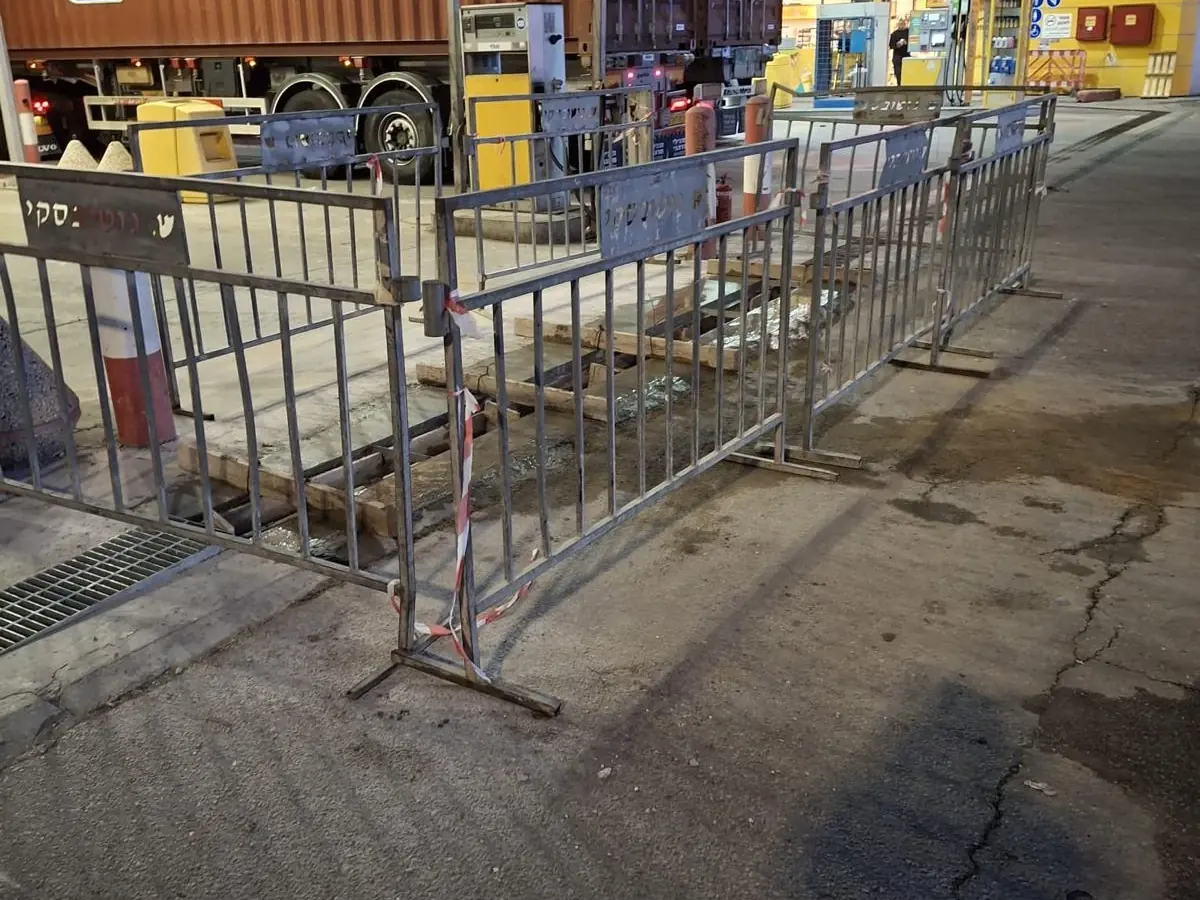 אזור עבודה מגודר בגדרות ממותגות ש. גוטובסקי בתחנת דלק בלילה